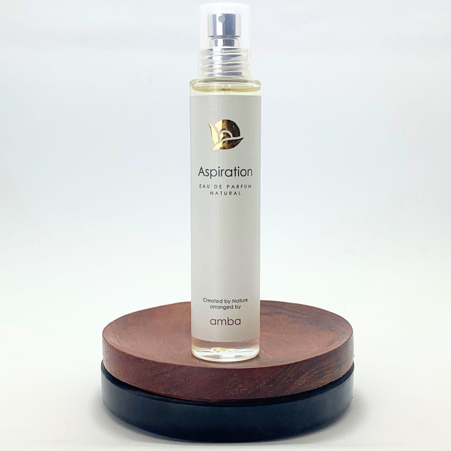 Naturparfüm amba Aspiration Flakon auf Holzsockel vor weißem Hintergrund