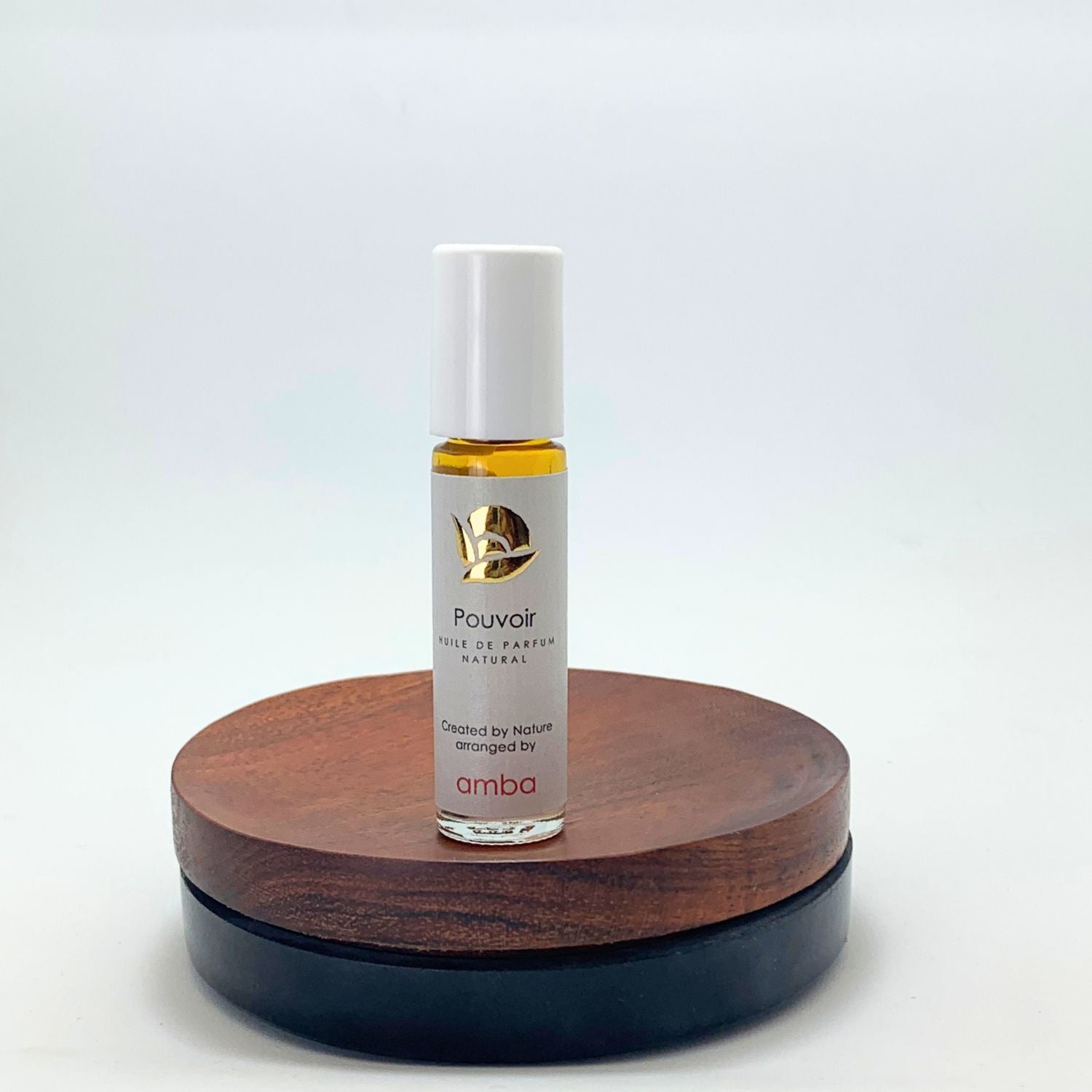 Roll On Pouvoir von amba auf Holzsockel vor weißem Hintergrund