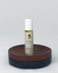 Roll-on des Grace Naturparfums von amba auf Holzsockel vor weißem Hintergrund