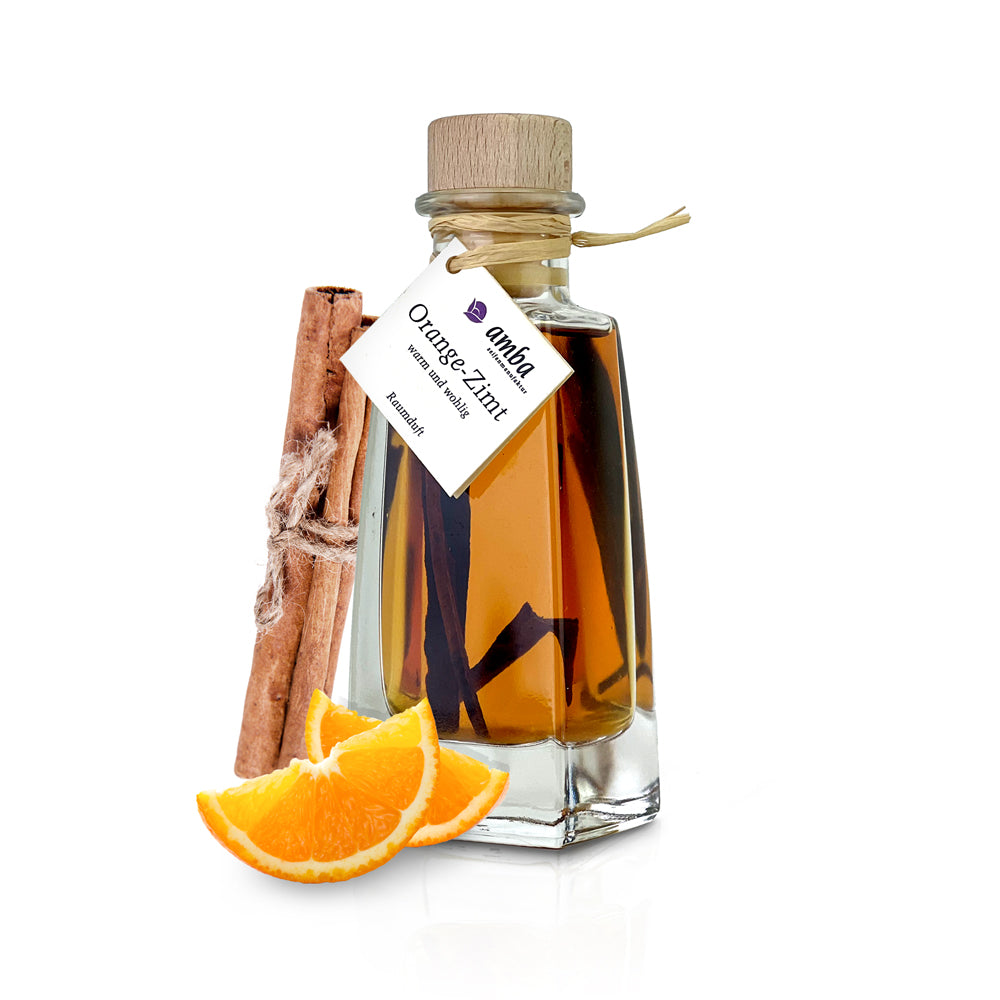 Orange Zimt Raumduft - Glasflasche mit Flüssigkeit 100ml und Zimstangen darin. An der Flasche außen sind Zimstangen, Orangenstücke angelehnt.