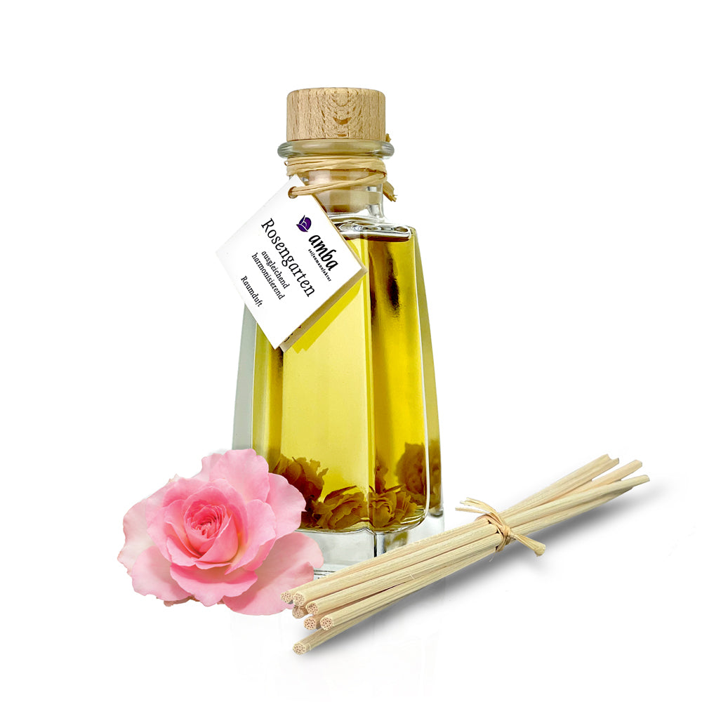 Raumduft Rosengarten in der Glasflasche mit Korken, Stäbchen und eine rosa Rose