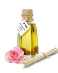 Raumduft Rosengarten in der Glasflasche mit Korken, Stäbchen und eine rosa Rose
