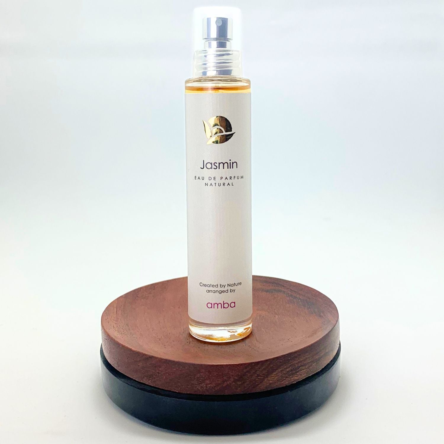 Flakon des Jasmin Naturparfums von amba auf Holzsockel vor weißem Hintergrund