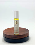Roll-on des Mystic Rose Naturparfums von amba auf Holzsockel vor weißem Hintergrund