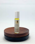 Roll-on des Relax Naturparfums von amba auf Holzsockel vor weißem Hintergrund