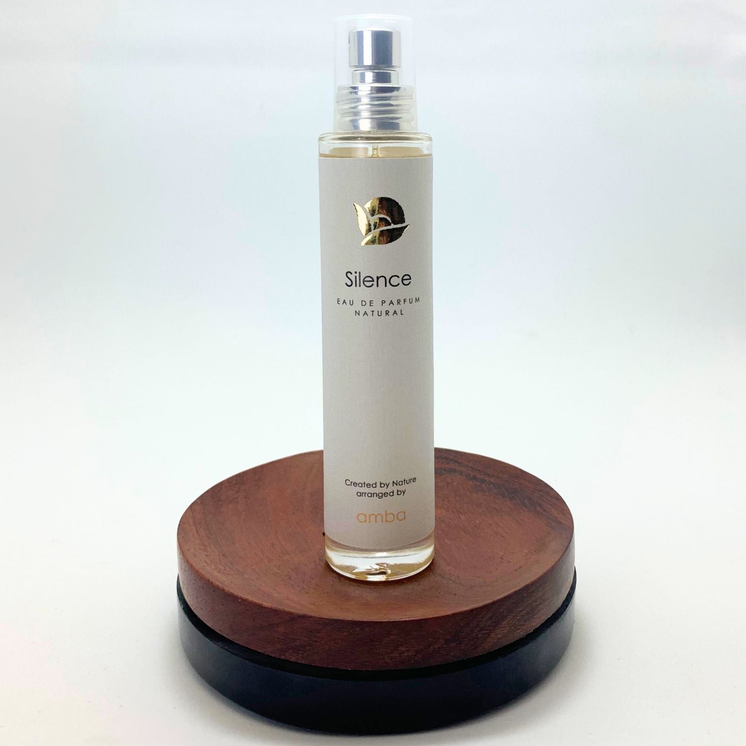 Flakon des Naturparfums Silence von amba auf Holzsockel vor weißem Hintergrund